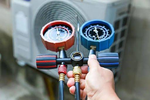 HVAC technician checking a heat pump's refrigerant level