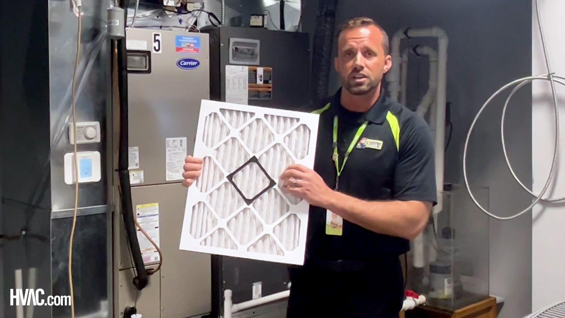 HVAC technician holding air filter