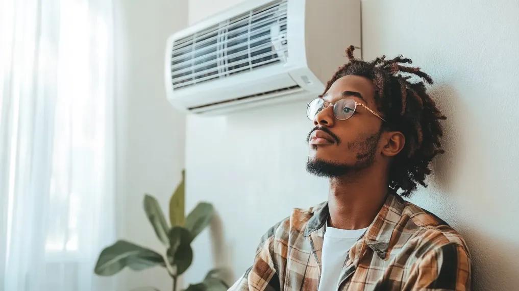 Man resting next to a mini-split air handler