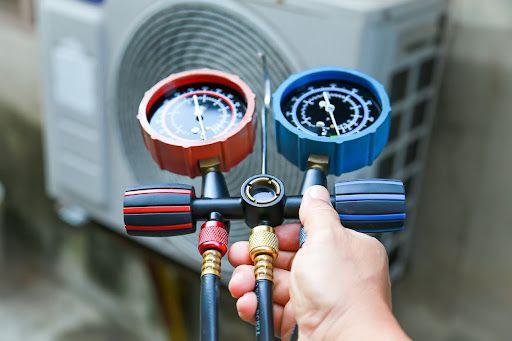 HVAC technician checking heat pump's refrigerant level